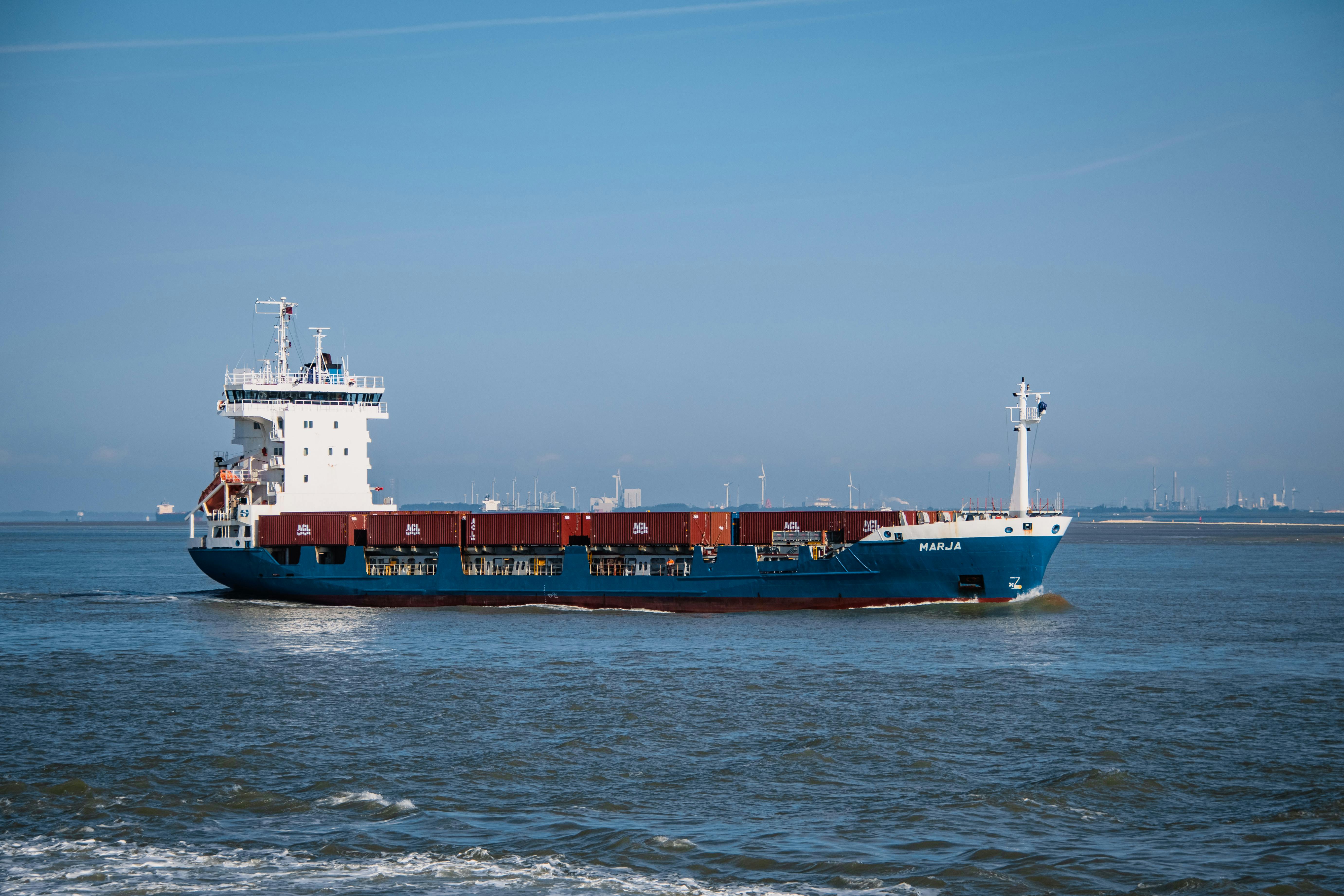 pexels-photo-9465721-9465721 A cargo ship with containers sails in a clear blue sea near Terneuzen, Netherlands.